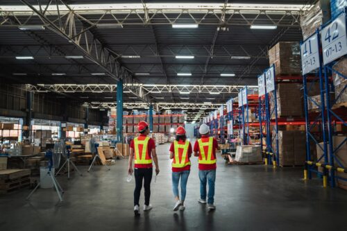 Warehouse workers walking to check details stock product in the background warehouse., Industrial and industrial concept.